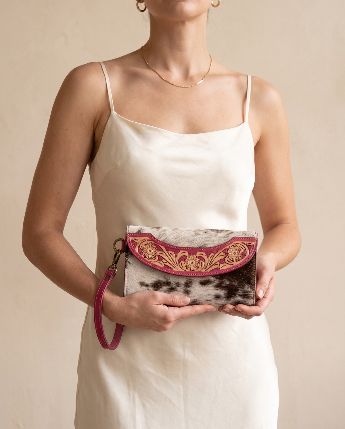 Pink cowhide wallet with curved hand-tooled flap, worn by a model, by Ya Qalbi