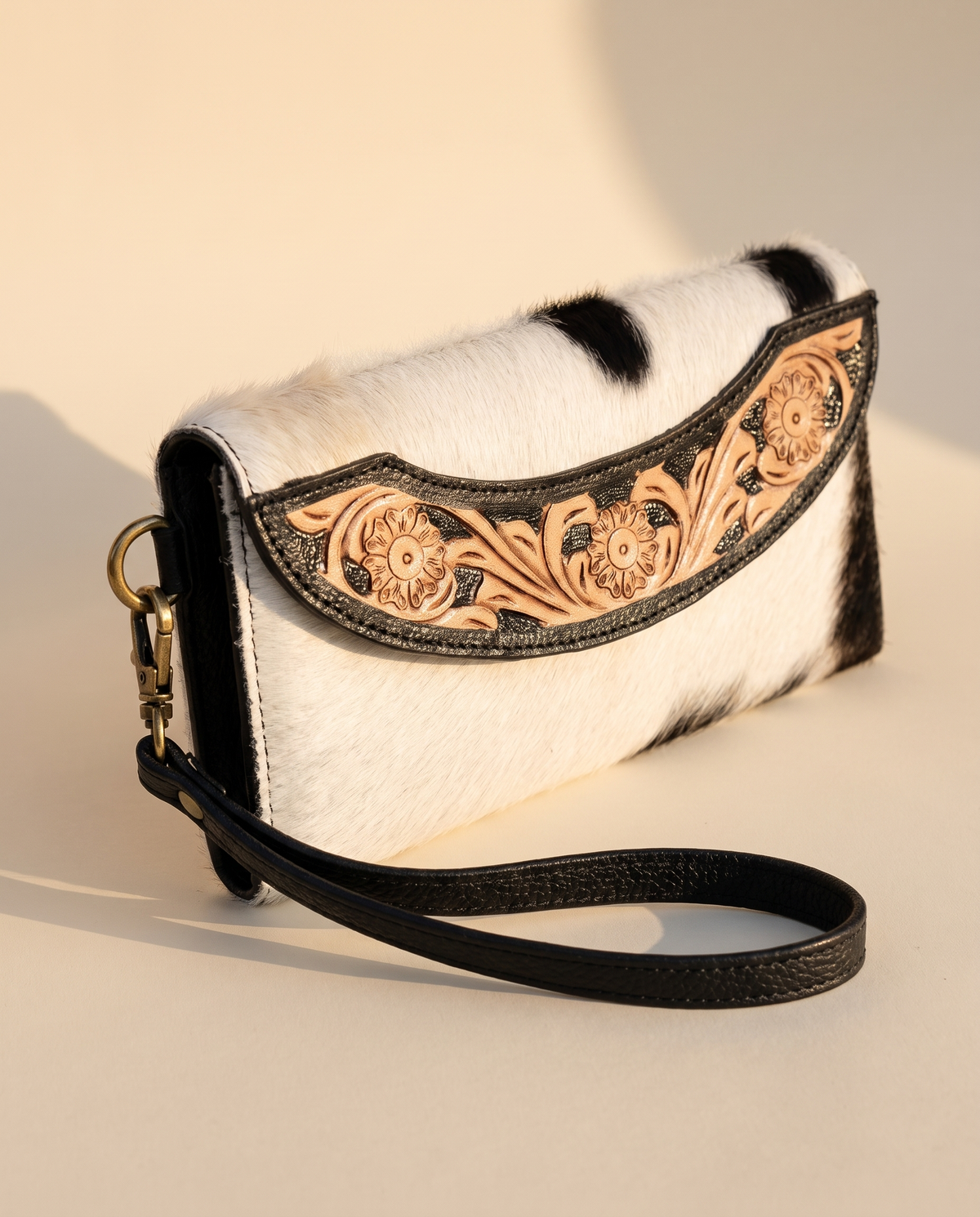 Black cowhide wallet with curved hand-tooled flap, angled view, by Ya Qalbi