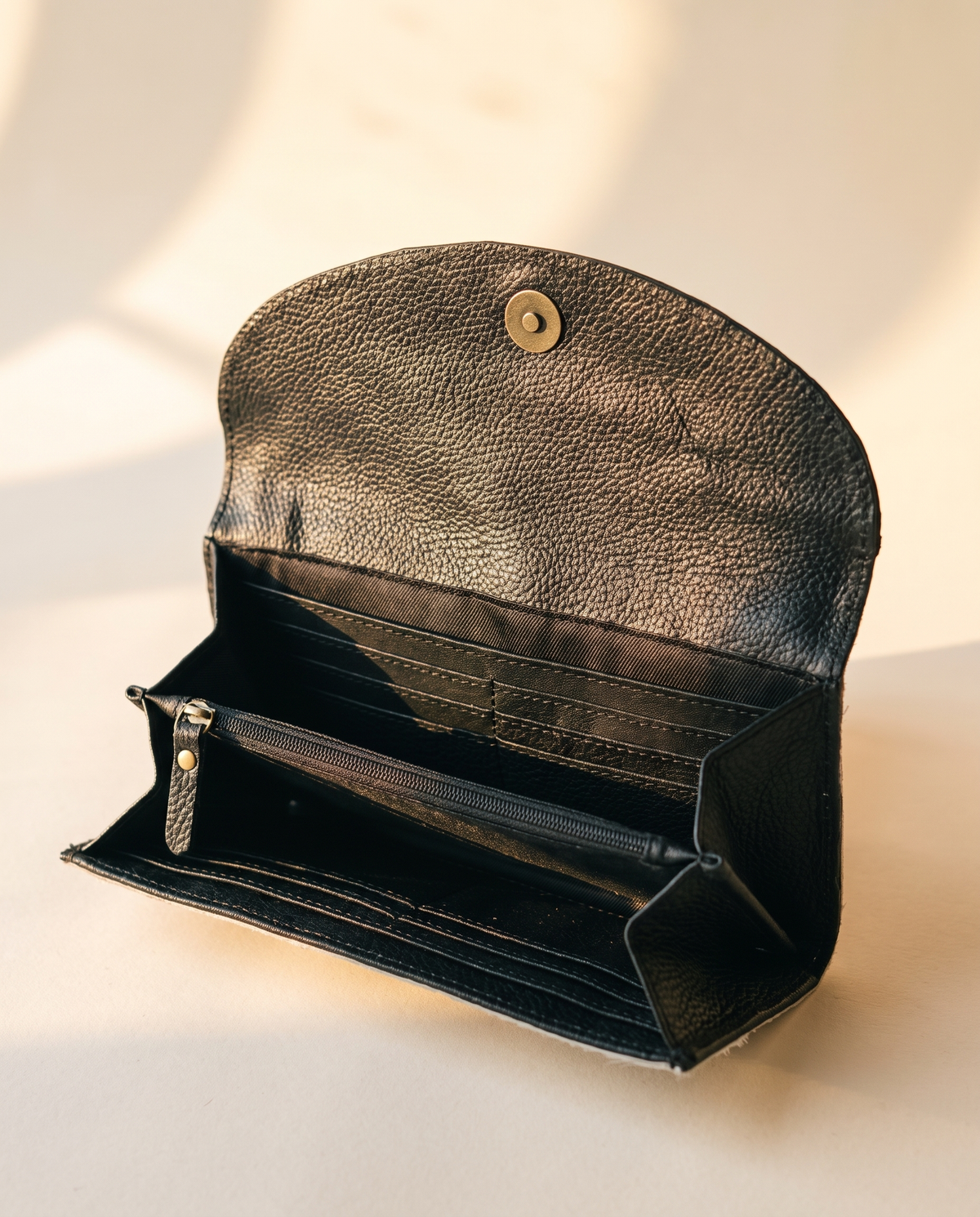 Black cowhide wallet with curved hand-tooled flap, open interior view, by Ya Qalbi