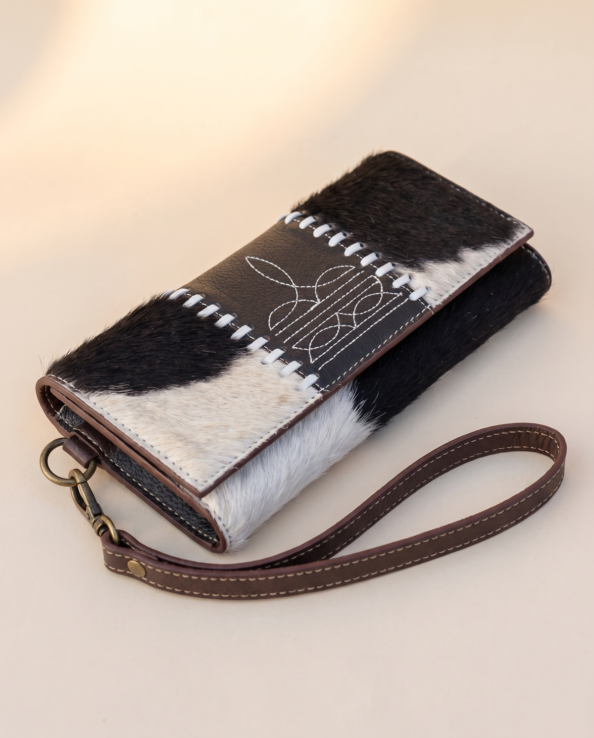 Black and White cowhide wallet with bootstitch leather panel, angled view, by Ya Qalbi