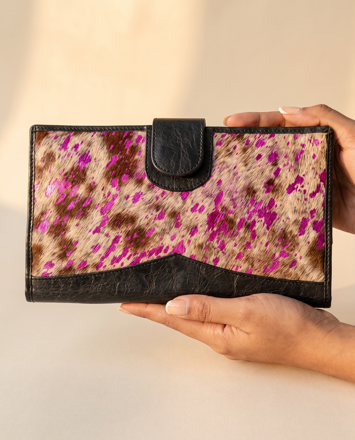 Metallic pink speckle cowhide wallet, held in hand, by Ya Qalbi