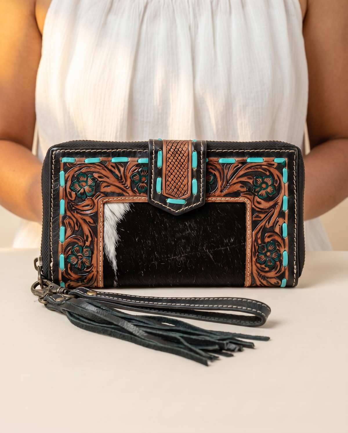 Black zip wallet with cowhide and turquoise tooled trim, worn by a model, by Ya Qalbi