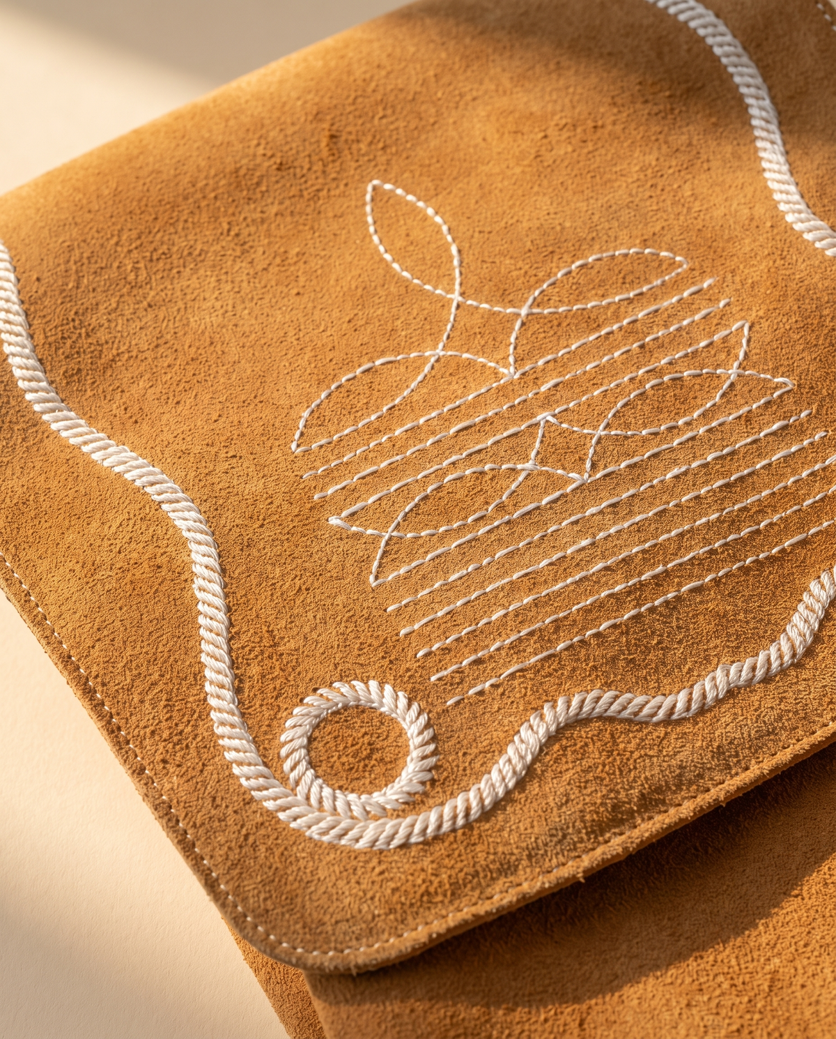 Bootstitch embroidery on tan suede flap