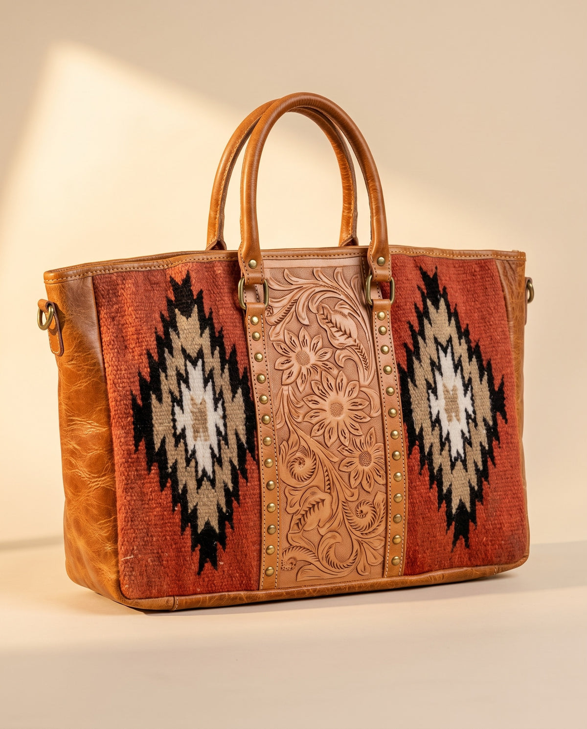 Rust Aztec woven leather zip tote with studded tooled strip, angled view with shoulder strap, by Ya Qalbi