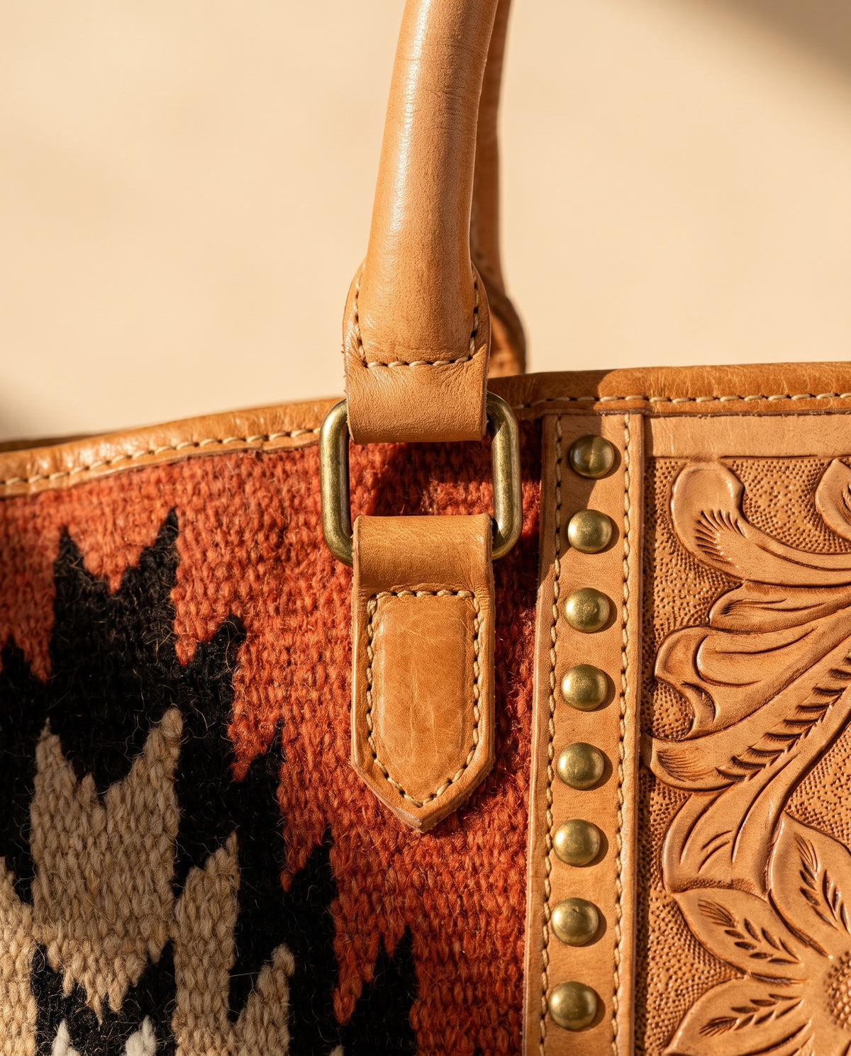 Rust Aztec woven leather zip tote with studded tooled strip, handle and studded tooled strip close-up, by Ya Qalbi