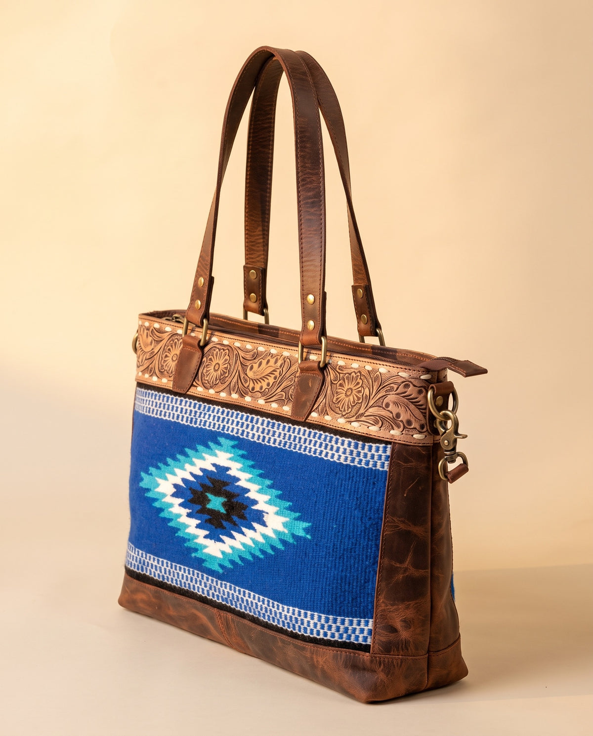 Blue serape woven zip tote with tooled leather band, angled view, by Ya Qalbi