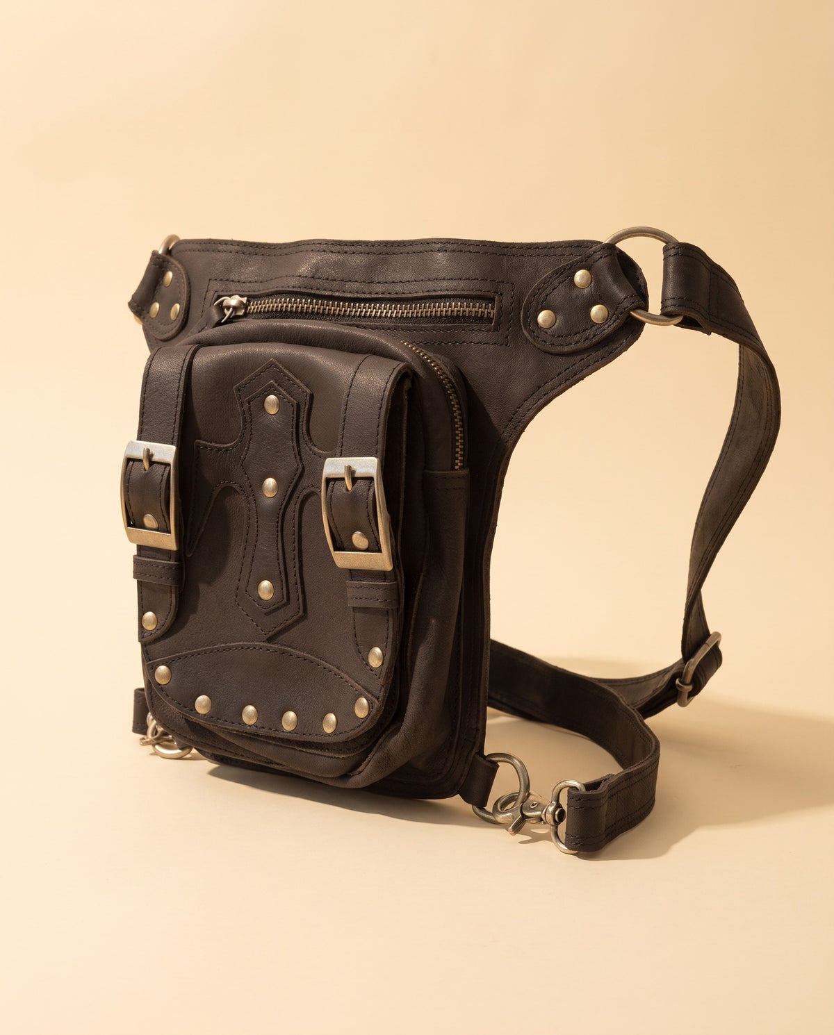 Black studded leather leg bag with buckles, angled view, by Ya Qalbi