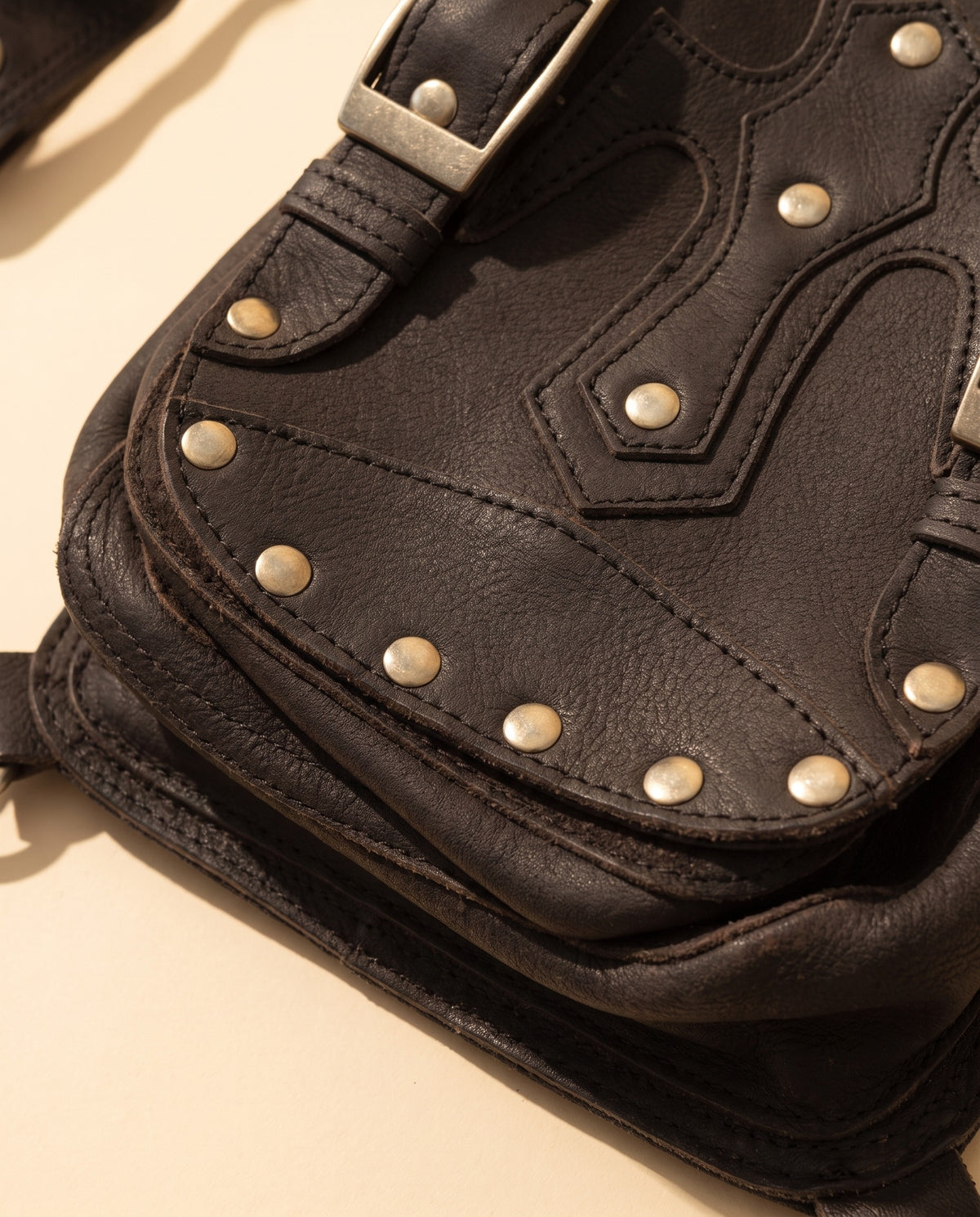 Black studded leather leg bag with buckles, detail close-up, by Ya Qalbi