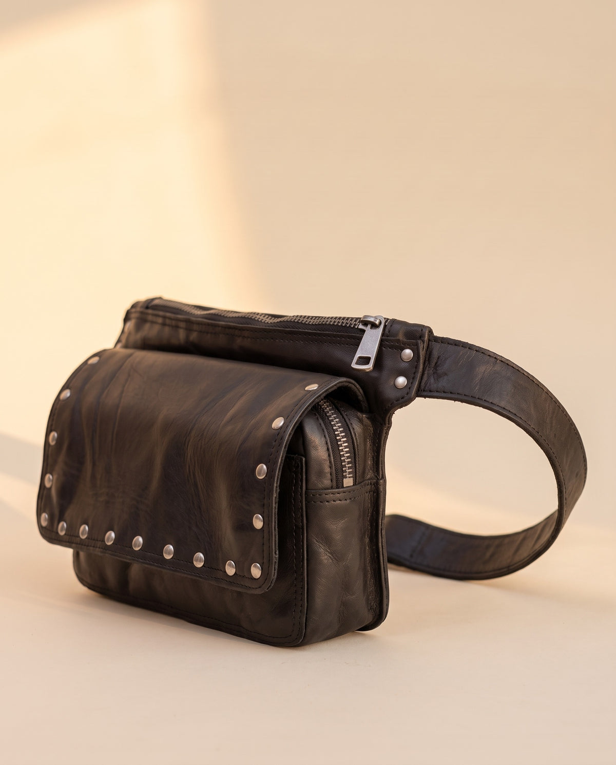 Black studded leather fanny pack, angled view, by Ya Qalbi