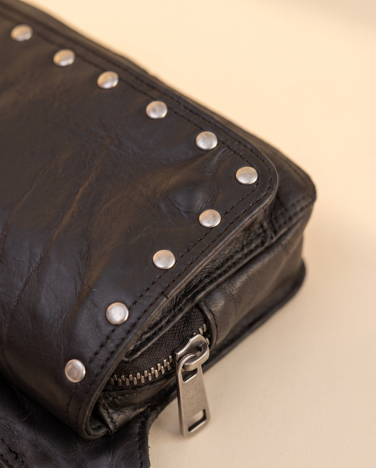 Black studded leather fanny pack, detail close-up, by Ya Qalbi
