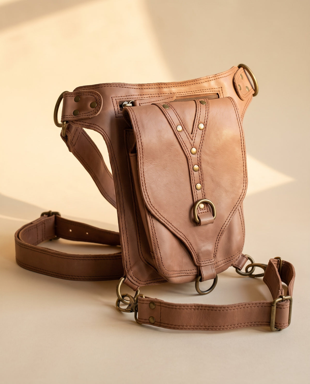 Blush studded leather hip belt bag, angled view, by Ya Qalbi