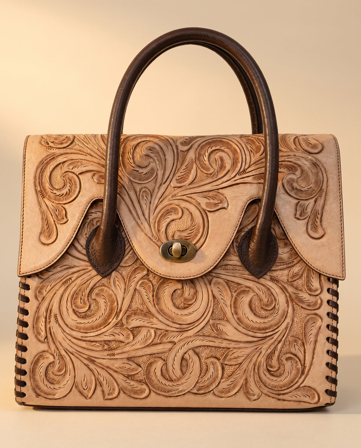 Tan hand-tooled leather top-handle handbag, front view, by Ya Qalbi