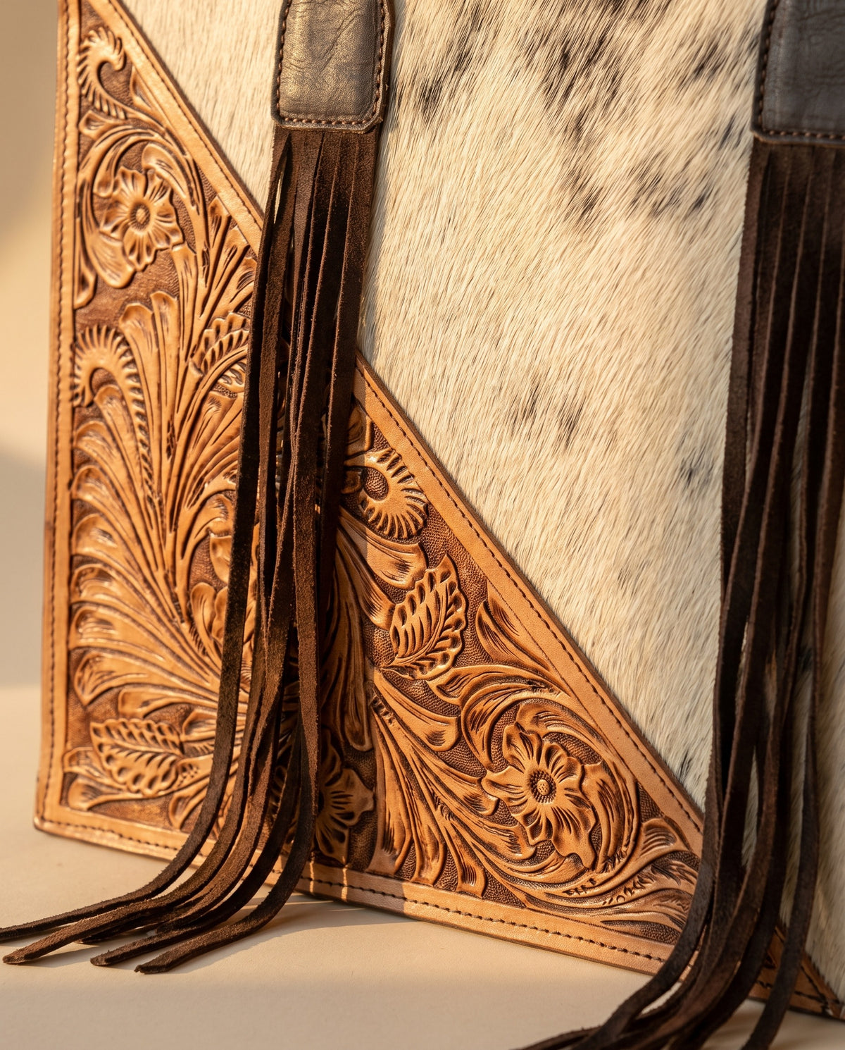 Tan tooled triangle hair-on cowhide leather tote with fringe, tooled corner panel and fringe close-up, by Ya Qalbi
